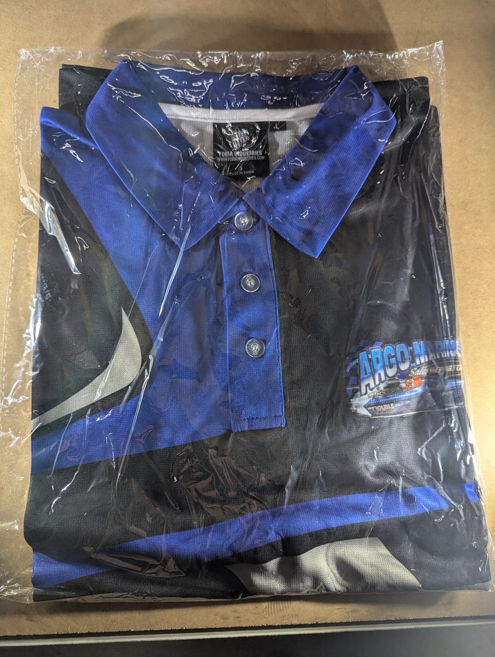 Folded Argo Marine Shepparton polo shirt in protective bag showing collar and chest logo.